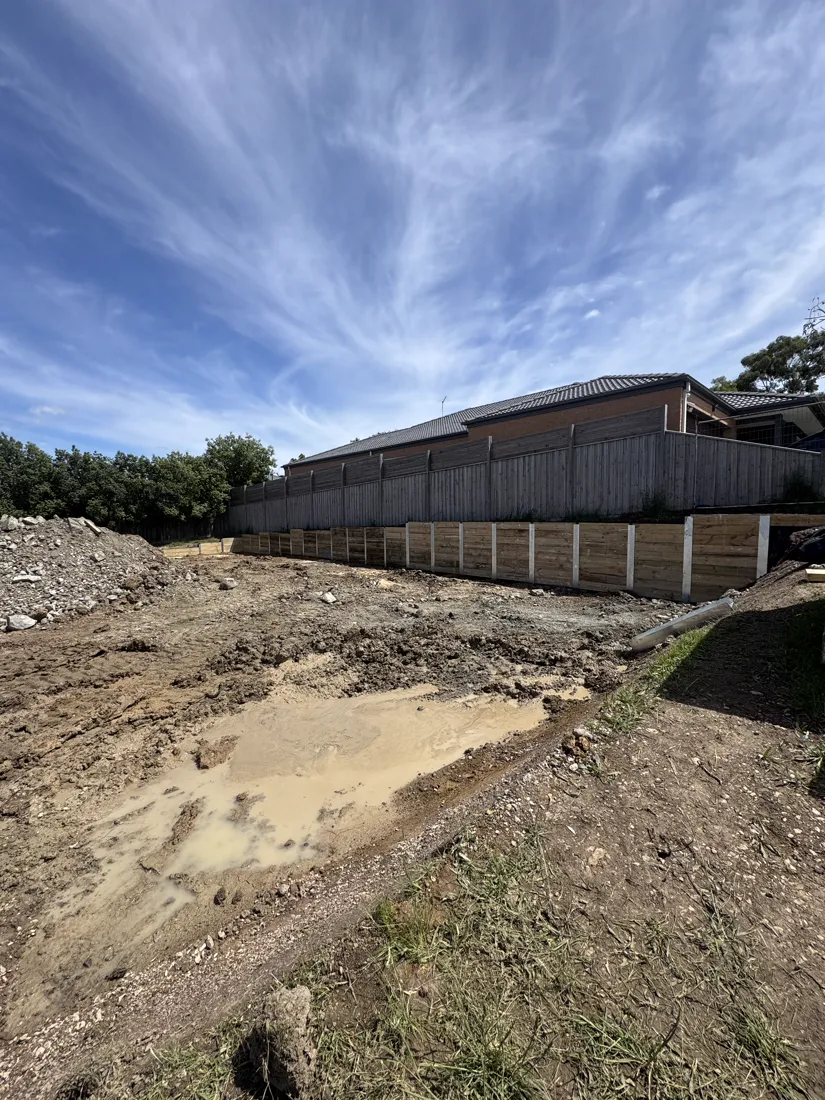 Sleeper retaining walls and site cut behind a new home