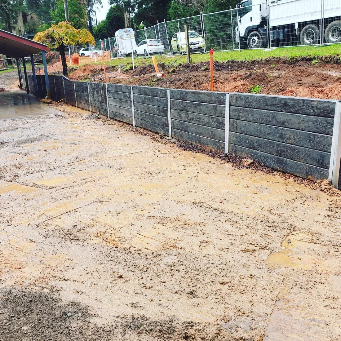 Grey sleeper retaining wall on a commercial roadside site